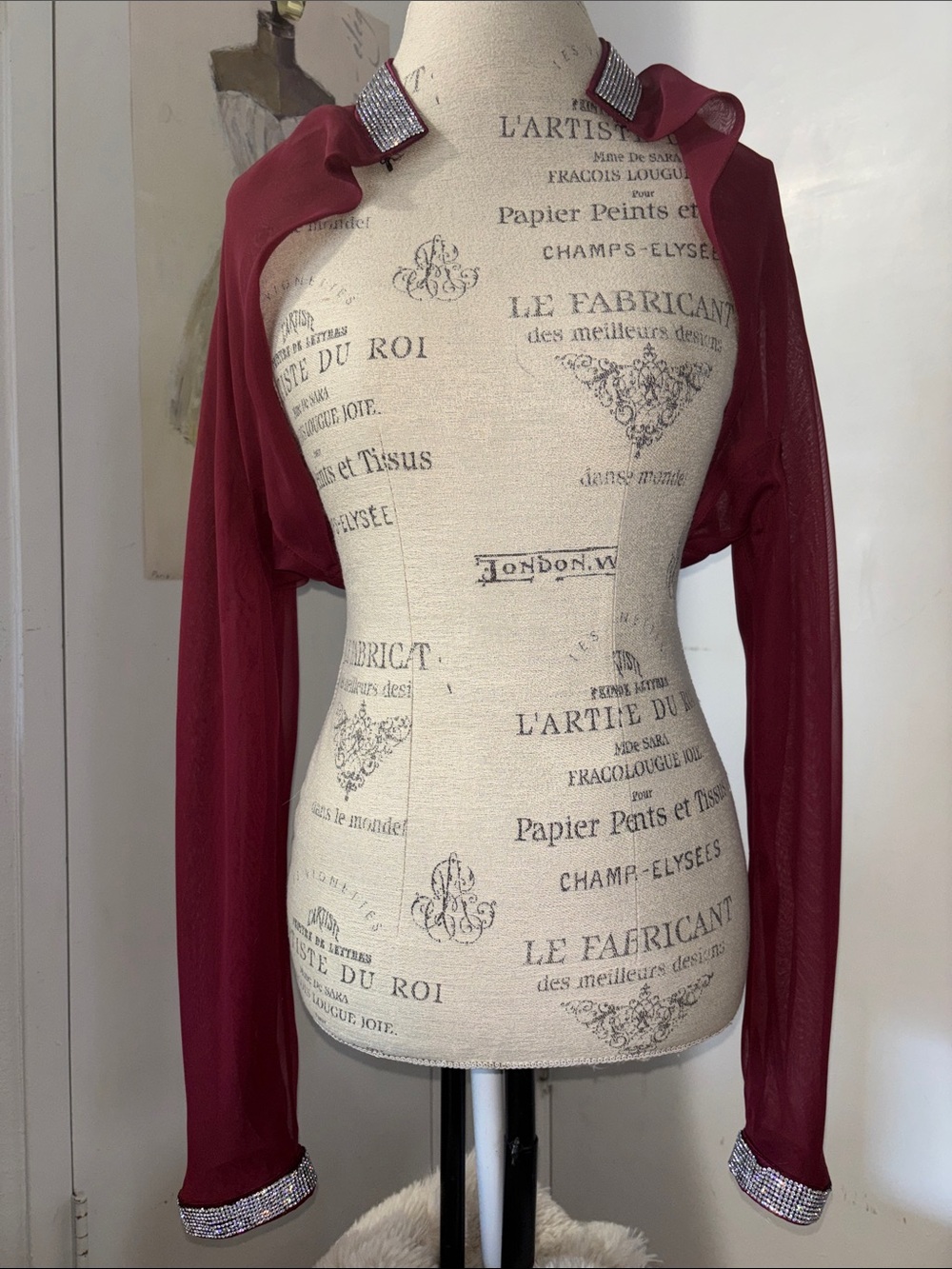 Sheer burgundy shiffon bolero features eye-catching rhinestone tr